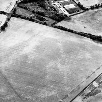 Oblique aerial view centred on the cropmarks of the ring-ditch, with the linear cropmarks adjacent, taken from the NNE.