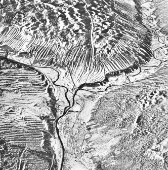 Oblique aerial view of Glen Ogil centred on the remains of buildings and field-walls, an enclosure, sheepfold, rig and a farmstead, taken from the S.