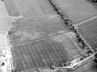 Oblique aerial view centred on the cropmarks of pits, a roundhouse, possible enclosure and rig, taken from the NNE.