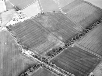 Oblique aerial view centred on the cropmarks of pits, a roundhouse, possible enclosure and rig, taken from the NW.