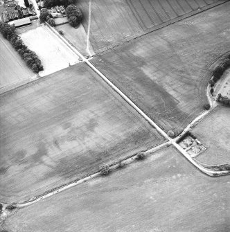 Pitskelly, oblique aerial view, taken from the S, centred on a cropmark complex.  A second enclosure and rig are visible in the centre right corner of the photograph.