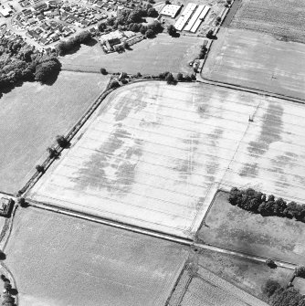 Oblique aerial view centred on the cropmarks of the unenclosed settlement, enclosures, pit-alignment, trackway and rig, taken from the NE.