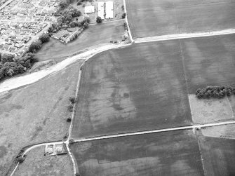 Oblique aerial view centred on the cropmarks of the unenclosed settlement, enclosures and rig with the possible enclosure and further rig adjacent, taken from the NE.