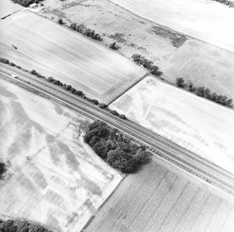 Oblique aerial view centred on the cropmarks of the Roman temporary camp and the rig, taken from the SE.