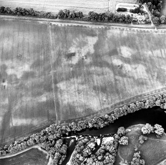 Oblique aerial view centred on the cropmarks of the possible ring-ditch and possible pit-enclosure, taken from the NNW.