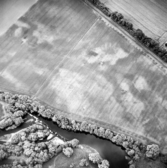 Oblique aerial view centred on the cropmarks of the possible ring-ditch and possible pit-enclosure, taken from the WNW.