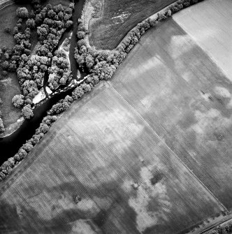 Oblique aerial view centred on the cropmarks of the possible ring-ditch and possible pit-enclosure, taken from the SSW.