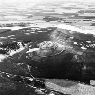 Oblique aerial view of White Caterthun centred on the remains of a fort, taken from the NNE.