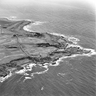 Oblique aerial view centred on the remains of the linear earthwork with farm, building and coastguard station adjacent, taken from the SE.