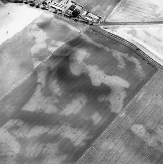 Westfield, oblique aerial view, taken from the WNW, centred on the cropmarks of rig, a souterrain, pits and a possible round house. The cropmark of an enclosure is visible in the top left-hand corner of the photograph.