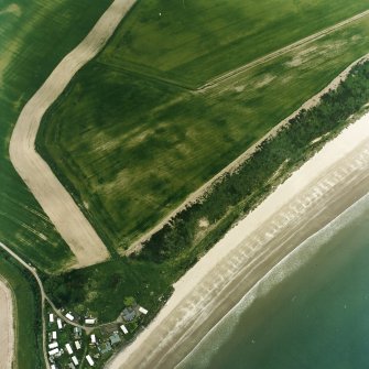 Oblique aerial view centred on the cropmarks of the unenclosed settlement, enclosures, possible souterrains and linear cropmarks, taken from the ESE.