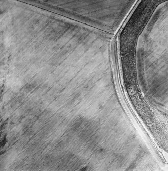 Oblique aerial view centred on the cropmarks of the unenclosed settlement, enclosures, possible souterrains, linear cropmarks and possible field boundaries, taken from the ESE.