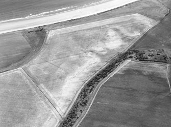 Oblique aerial view centred on the cropmarks of the unenclosed settlement and linear cropmarks, taken from the WNW.