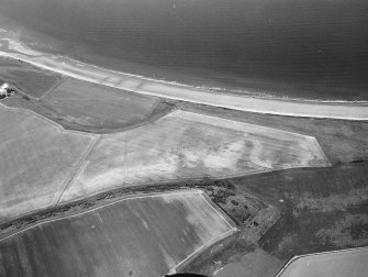 Oblique aerial view centred on the cropmarks of the unenclosed settlement and linear cropmarks, taken from the WSW.