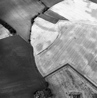 Newbarns Smithy, oblique aerial view, taken from the ESE, centred on cropmarks including those of an unenclosed settlement and a field boundary. Further cropmarks are visible in the bottom half of the photograph.