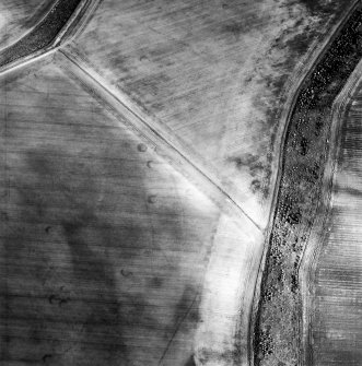 Oblique aerial view centred on the cropmarks of the unenclosed settlements, linear cropmarks, souterrains, possible field boundaries and field system, taken from the WNW.