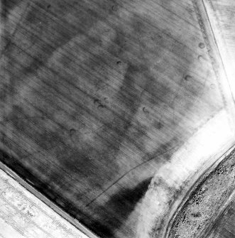 Oblique aerial view centred on the cropmarks of the unenclosed settlement, linear cropmarks and souterrains, taken from the WSW.