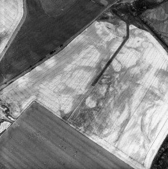 Kirkton Mill, oblique aerial view, taken from the SW, centred on the cropmarks of a round house and rig.