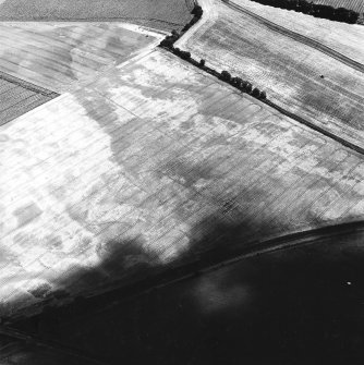 Oblique aerial view centred on the cropmarks of the unenclosed settlements, pit-alignment, possible enclosure, rig and pits,  taken from the NW.