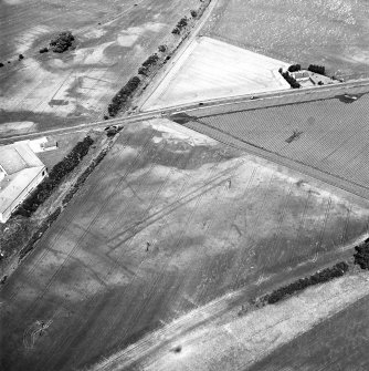 Gilrivie, oblique aerial view, taken from the SW, centred on the cropmarks of a possible unenclosed settlement, souterrains, pits, a pit-alignment and linear cropmarks. An enclosure and linear cropmarks  are visible in the top left-hand corner of the photograph.