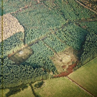 Oblique aerial view centred on the remains of the recumbent stone circle, cairn and ring cairn with cairn adjacent, taken from the SSW.