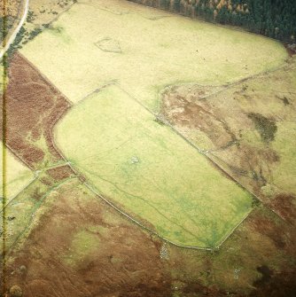 Oblique aerial view centred on the remains of the field-system and clearance cairns with recumbent stone circle and ring cairn adjacent, taken from the NNE.