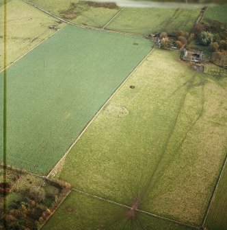 Oblique aerial view centred on the remains of the stone circle and cairn, taken from the WSW.