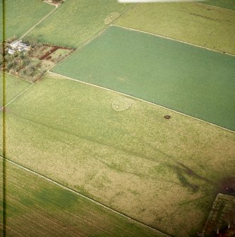 Oblique aerial view centred on the remains of the stone circle and cairn with the recumbent stone circle adjacent, taken from the SE.