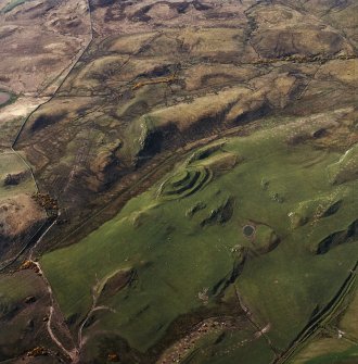 Oblique aerial view centred on the remains of the fort and rig, taken from the N.

