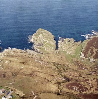 Oblique aerial view centred on the remains of the fort and dun with lazy-beds adjacent, taken from the SE.