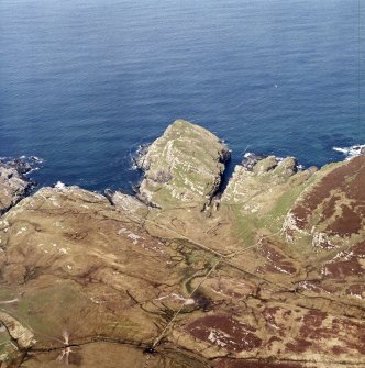 Oblique aerial view centred on the remains of the fort and dun with lazy-beds adjacent, taken from the ESE.