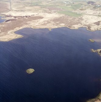 Oblique aerial view centred on the site of the castle with the remains of the possible crannog, farmstead, rig and township adjacent, taken from the SW.