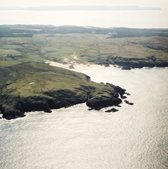 General oblique aerial view looking across the remains of the fort and Lossit Bay towards the S coast of Islay, taken from the NW.