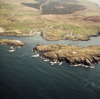 General oblique aerial view centred on the villages, lighthouse, cottage and remains of the chapel and burial ground, taken from the SW.