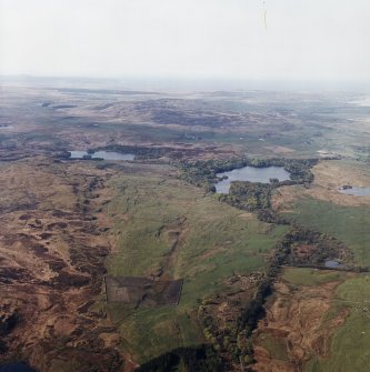 General oblique aerial view looking across the remains of the township towards the crannog and island-dwelling, taken from the NE.