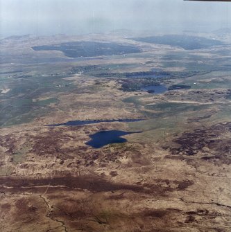 General oblique aerial view looking across Loch Leathann and Loch Fada towards the island-dwelling, crannog, village and the N coast of Islay, taken from the SE.
