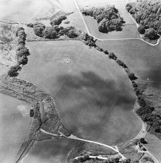 Oblique aerial view centred on the remains of the cairn, cropmarks of the possible field boundaries and further cropmarks, taken from the ENE.
