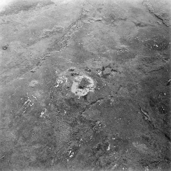 Oblique aerial view centred on the remains of the dun, taken from the NW.