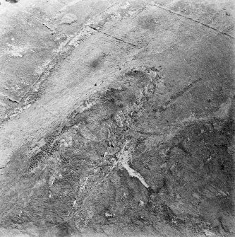 Oblique aerial view centred on the remains of the fort with rig and field banks adjacent, taken from the NW.