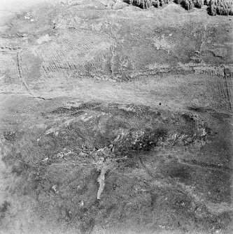 Oblique aerial view centred on the remains of the fort with rig and field banks adjacent, taken from the WNW.