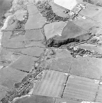 Oblique aerial view centred on the remains of the dun with the township adjacent, taken from the SE.