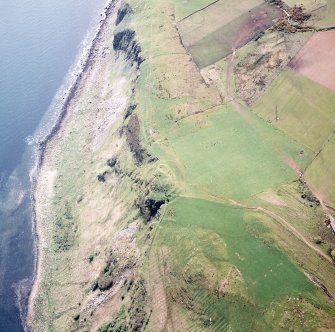 Oblique aerial view centred on the remains of the fort with the rig adjacent, taken from the NE.