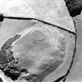 Oblique aerial view of Dowan's Hill centred on the remains of a fort with the cropmarks of another possible fort and rig adjacent, taken from the NE.