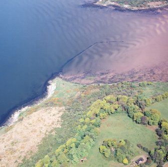 Oblique aerial view centred on the remains of the fish trap with the remains of the tower adjacent, taken from the SSW.