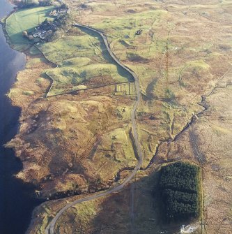 Oblique aerial view centred on the remains of the military camp with the farmsteading and sheepfold adjacent, taken from the N.