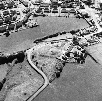 Oblique aerial view centred on the remains of the motte-and-bailey castle, taken from the N.
