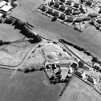 Oblique aerial view centred on the remains of the motte-and-bailey castle, taken from the NW.