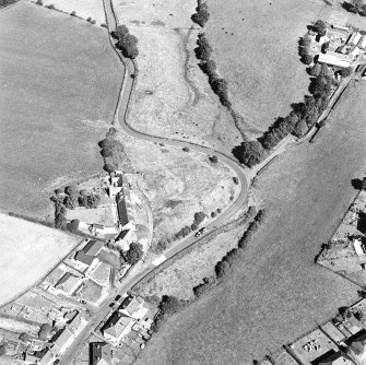 Oblique aerial view centred on the remains of the motte-and-bailey castle, taken from the SW.