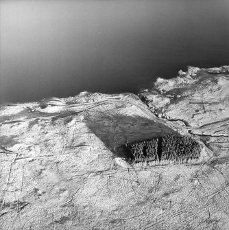 Oblique aerial view centred on the remains of the military camp, taken from the WNW.