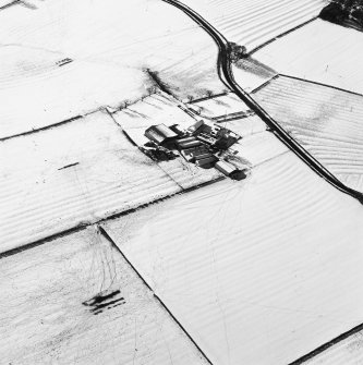 Oblique aerial view centred on the farmsteading with rig adjacent, taken from the ENE